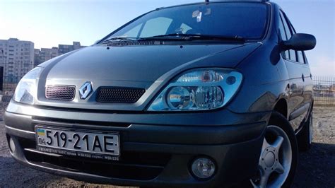 Teminė nuotrauka: priekinė Renault Scenic 2003 dalis su įjungtais priešrūkiniais žibintais