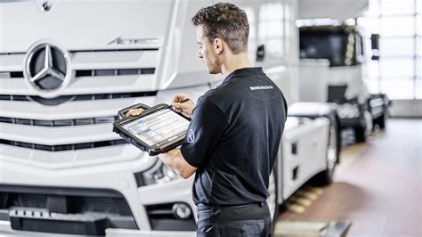Serviso darbuotojas atlieka kompiuterinę diagnostiką Kia automobiliui