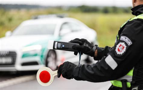 Automobilio stabdymo iliustracija su policijos pareigūnais ir alkotesteriu