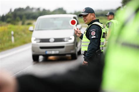 Tematinė nuotrauka: policijos pareigūnas stabdo automobilį naktį