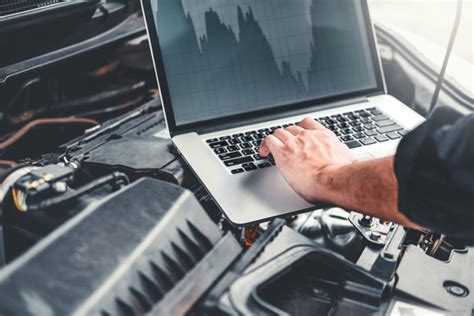 Automechanikas atliekantis kompiuterinę diagnostiką automobiliui