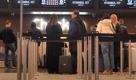 Šeima oro uoste su lagaminu, besiruošianti kelionei