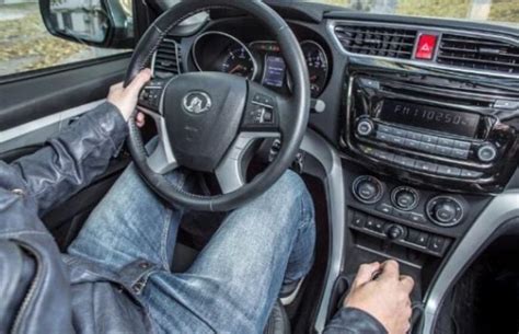 Teminė nuotrauka su automobilio vairo ir vairuotojo rankų siluetu