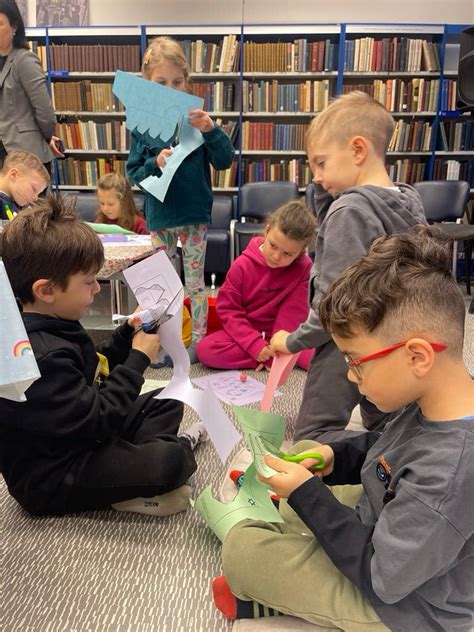 Priešmokyklinukai bibliotekoje, apsupti knygų