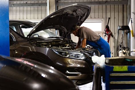 Serviso meistras dirba su automobilio varikliu