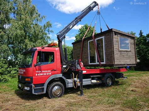 Iliustracija, vaizduojanti miškovežio su kranu ir hidrauliniu manipuliatoriumi konstrukciją.