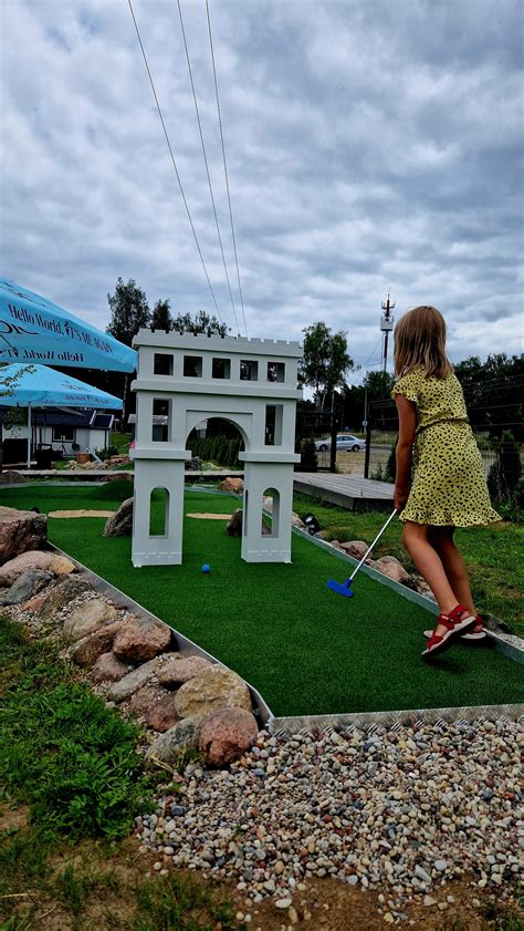 Iliustracija, vaizduojanti vaiką, žaidžiantį lauke mieste, su pavaizduotomis oro taršos dalelėmis.