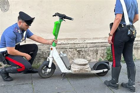 Jaunas žmogus važiuojantis elektriniu paspirtuku miesto gatvėje