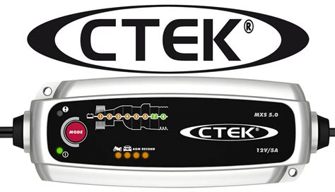 Tematinė nuotrauka: CTEK MXS 5.0 įkroviklis prijungtas prie automobilio akumuliatoriaus, fone automobilio variklio skyrius