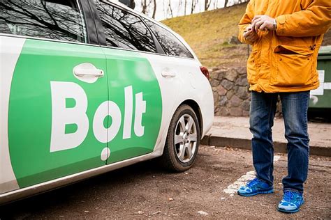 Bolt vairuotojas, žiūrintis į savo Bolt programėlę ir žemėlapį
