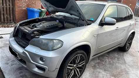 Tematinė BMW X5 variklio skyriaus nuotrauka su pažymėta pakaitinimo žvakių relės vieta