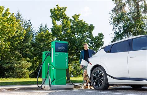 Nuotrauka, vaizduojanti elektromobilį įkrovimo stotelėje