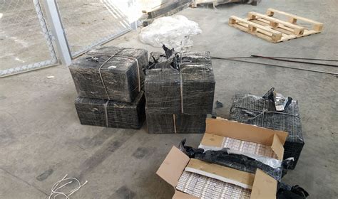 nuotrauka muitinės pareigūnų, tikrinančių puspriekabę su paslėpta kontrabanda