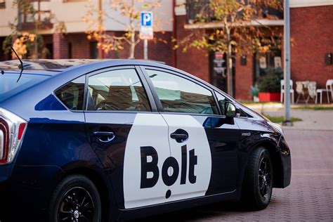 Nuotrauka: mandagus Bolt vairuotojas, atidarantis duris keleiviui.