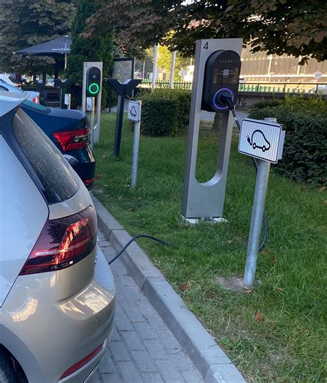 Nuotrauka, vaizduojanti elektromobilių įkrovimo stotelę autoserviso teritorijoje