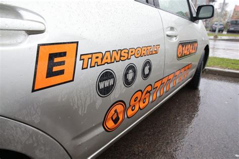 Taksi automobilio su ETRANSPORT logotipu vaizdas mieste