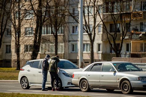 Pirkėjo ir pardavėjo rankos pasirašančios sutartį, fone automobilis