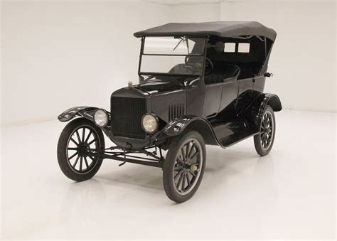 Nuotrauka, vaizduojanti istorinį „Ford Model T“ automobilį ir šiuolaikinį elektrinį „Ford“ modelį