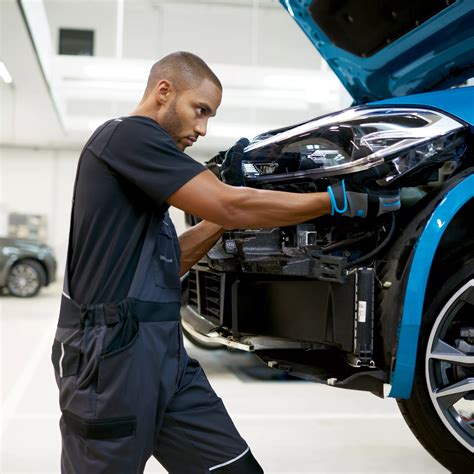 Teminė BMW serviso nuotrauka su meistrais dirbančiais prie automobilio