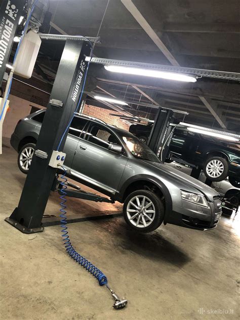Tematinė nuotrauka: profesionalūs mechanikai, atliekantys pneumatinės pakabos diagnostiką servise