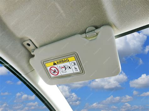 Infographic showing locations of airbag warning stickers in a car (sun visor and door pillar).