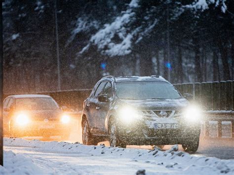 Tematinė nuotrauka su automobiliais lapkričio mėnesio kelyje esant prastoms oro sąlygoms (lietus, tamsa)