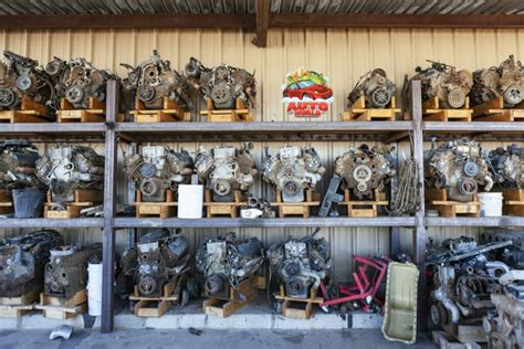 Photo of used car parts, including front fenders, at an auto salvage yard