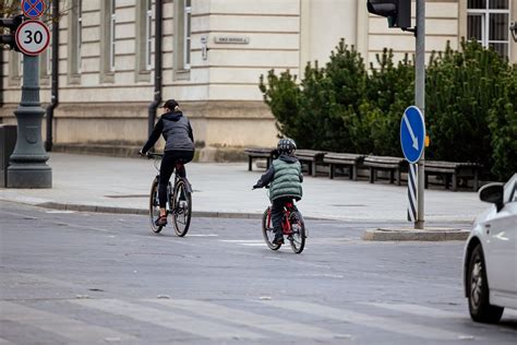 Tematinė nuotrauka: žmonės važiuojantys motoroleriais judriomis miesto gatvėmis