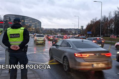 Policijos pareigūnai apžiūri avarijos vietą, matomas kelias ir pakelė