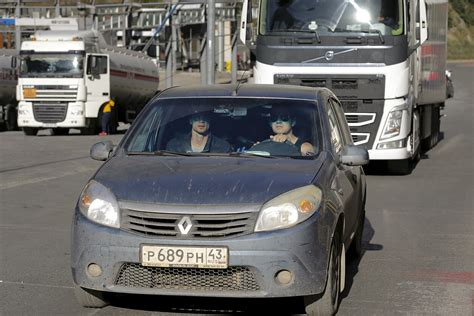 Sunkvežimio, kemperio ar motociklo nuotrauka važiuojančio keliu su rusiškais kraštovaizdžiais fone
