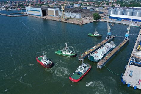 Nuotrauka su įvairiais terminaliniais vilkikais laivų uoste