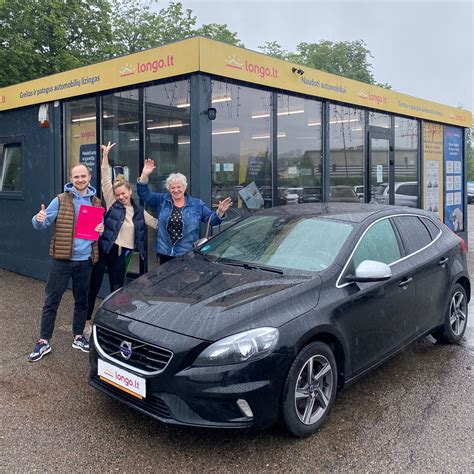 Laimingi klientai su ką tik įsigytu automobiliu prie salono