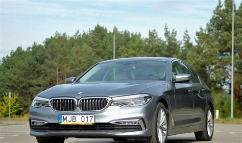 BMW 5 serijos skirtingų kartų (E60, F10, G30) evoliucijos infografika, pabrėžianti dizaino ir technologijų pokyčius