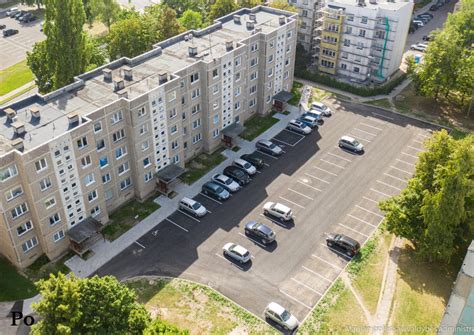 Teminė nuotrauka su perpildyta automobilių stovėjimo aikštele prie daugiabučių namų