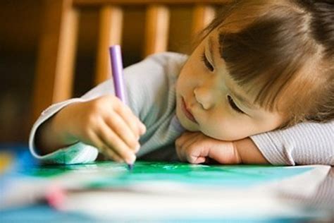 Vaikas piešia šeimos portretą, kuriame dominuoja kelios ryškios spalvos