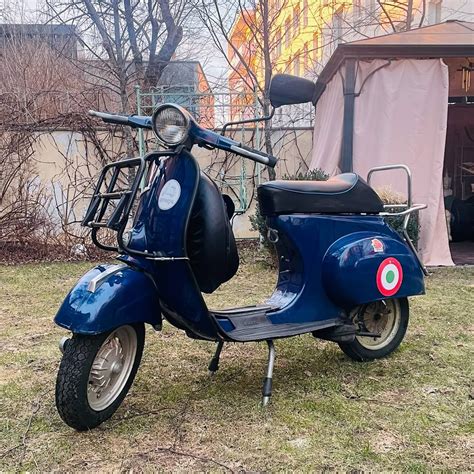 „Vespa“ motorolerių modelių rikiuotė miesto fone