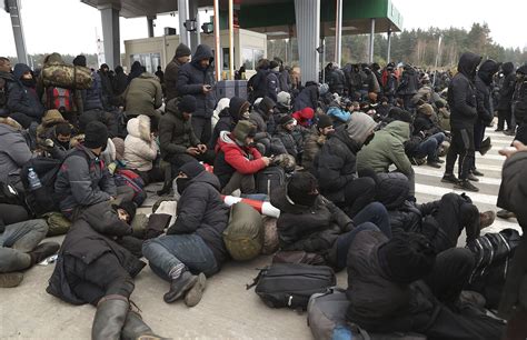 Migrantai, sėdintys prie greitkelio