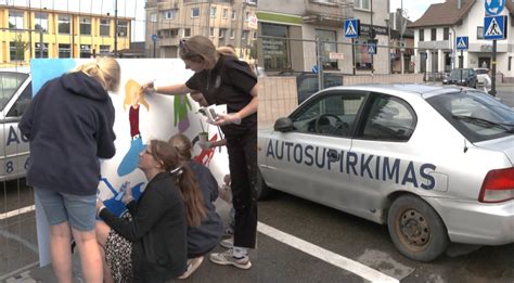 Automobilis su reklaminiais lipdukais mieste