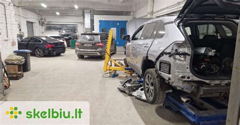 Autoserviso interjero nuotrauka su atliekamais kėbulo dažymo ir variklio remonto darbais