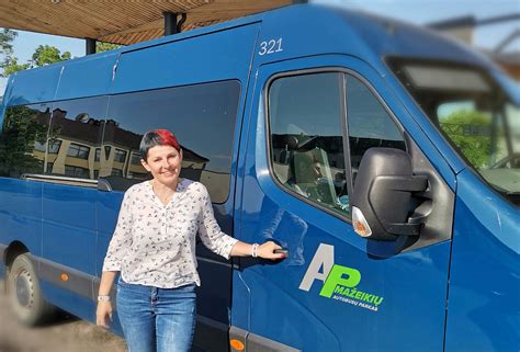 Teminė nuotrauka: besišypsanti autobusų vairuotoja už vairo