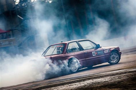 Burnout varžybų metu deginamų padangų dūmai ir žiūrovų minia
