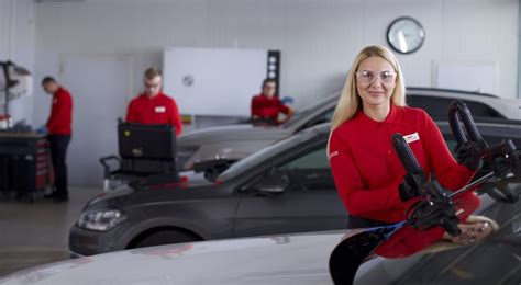 Melga autoserviso meistras montuoja naują automobilio stiklą