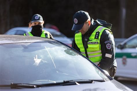 Policijos automobilio ir vairuotojo nuotrauka, iliustruojanti KET pažeidimų fiksavimą.