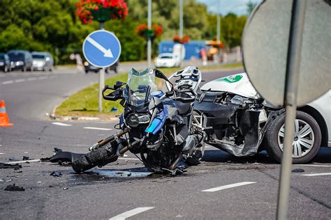 Motociklo avarijos padariniai su išsibarsčiusiomis nuolaužomis