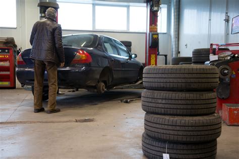automobilių serviso darbuotojas keičia padangas