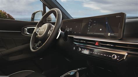 Vaizdas automobilio interjero su projekciniu ekranu ir patogiai išdėstytais valdymo prietaisais