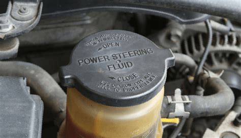 The power steering reservoir of a Ford Mondeo engine bay