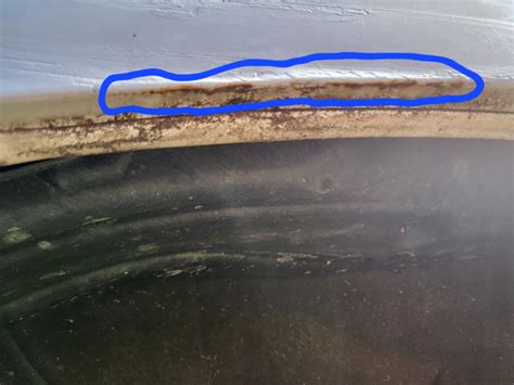 Close-up photo of rust spots on a car's wheel arch or door sill