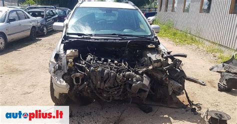 Mazda 626 su atidarytu variklio skyriumi ir pakeltu automobiliu servise
