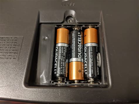 Photo demonstrating the use of a coin to open the battery compartment lid